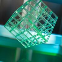 3D-gedruckter Würfel auf einem Harzdrucker mit Harz im Bottich