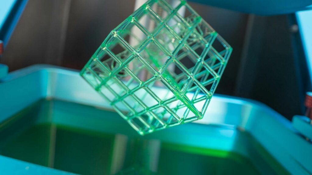 3D-gedruckter Würfel auf einem Harzdrucker mit Harz im Bottich