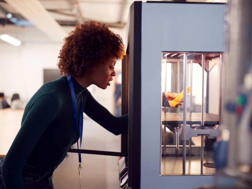 3d printer with woman looking at the print