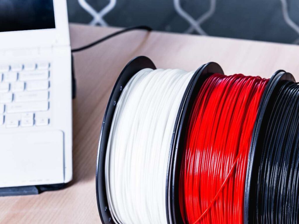 different spools of filament and laptop