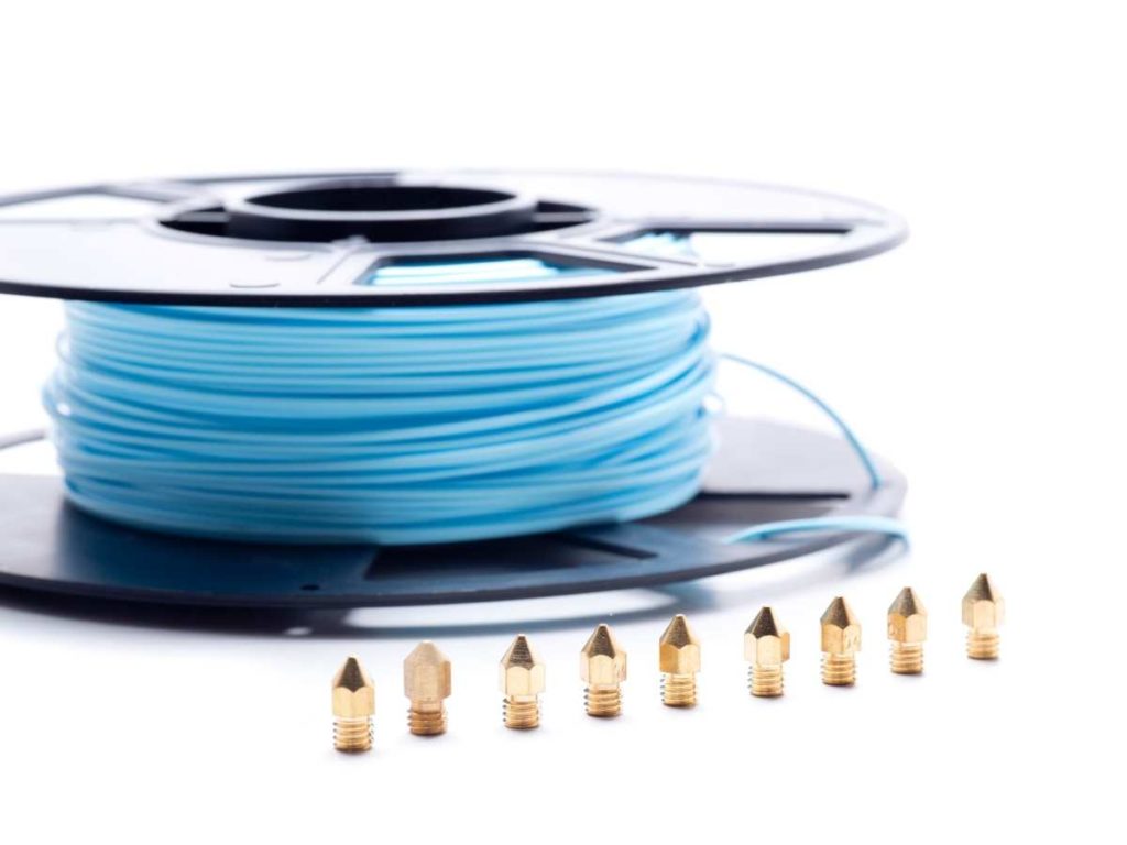 filament spool with differnt sizes of brass 3d printer nozzles