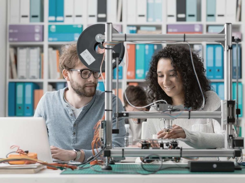 man and woman looking to a 3d printer