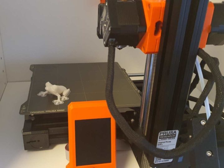 3d printer prusa mini with a 3d printed frog with a brim sticking to the bed