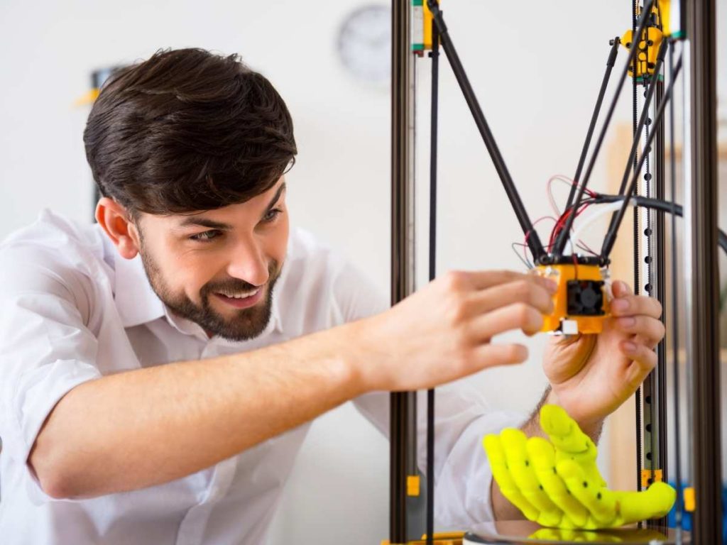 engineer working on the 3d printer after a long print job