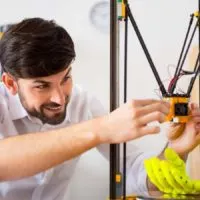 engineer working on the 3d printer after a long print job