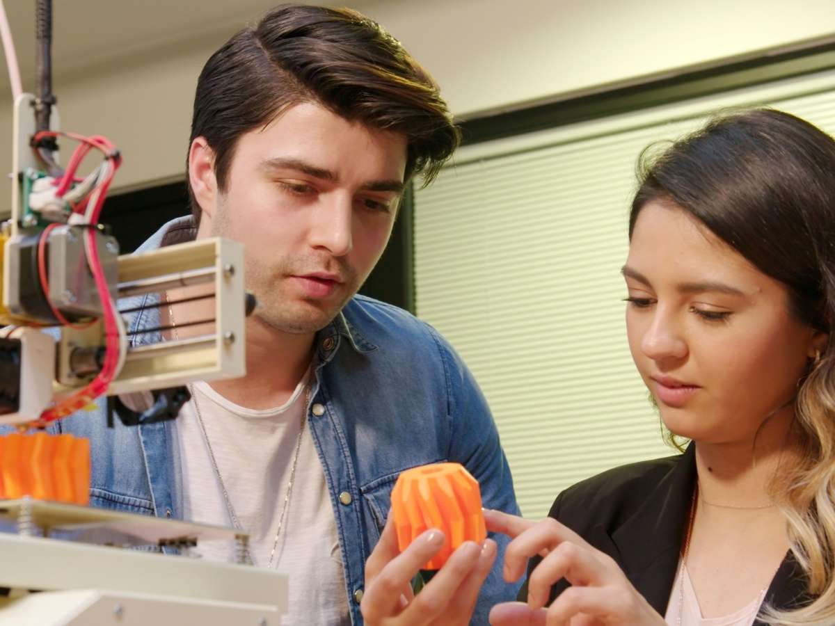 3d printer with 2 people and 2 3d printed objects